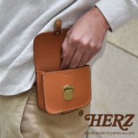 一款棕色皮革腰包，有金色鎖扣和搭扣，由手工縫製，展現職人技藝。