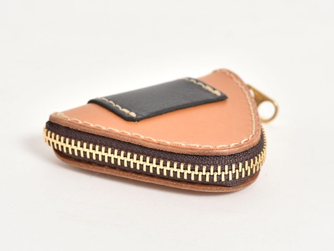 職人手作皮革三角飯糰造型零錢包，淺棕色皮革主體，搭配黑色皮革裝飾，使用金色拉鍊，縫線細緻。