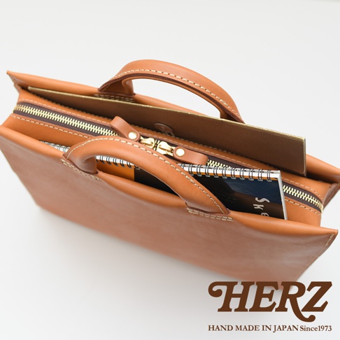 HERZ 職人手作皮革簡約商務公事包，棕色皮革，拉鍊開闔，內含筆記本，手把特寫，日本製造 since 1973