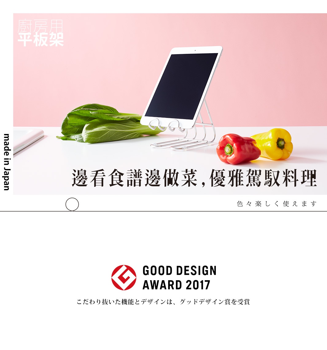 不鏽鋼萬用支架，銀色金屬材質，可放置平板電腦，旁邊擺放青江菜、紅椒和黃椒。