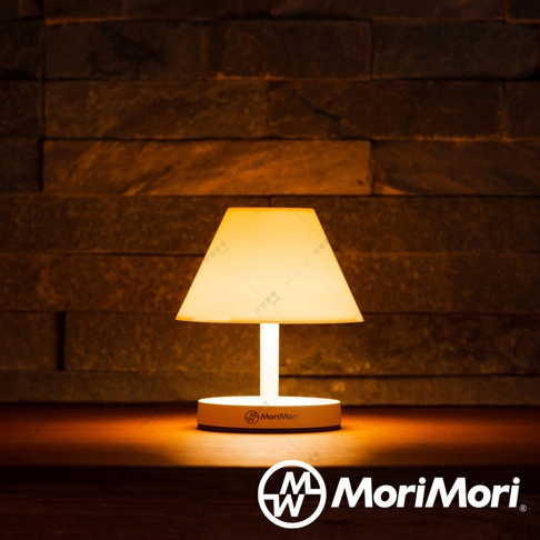 LED T-Light CAFE 傘型造型燈，白色燈罩呈梯形，搭配白色燈柱與圓形底座，散發柔和暖黃光。