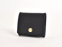 黑色皮革箱型零錢包，有金色按鈕開合，縫線整齊。
