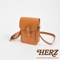 職人手作皮革散步包，原色牛皮材質，方型翻蓋設計，附有金屬釦與皮革束帶，可調節長度的肩背帶。