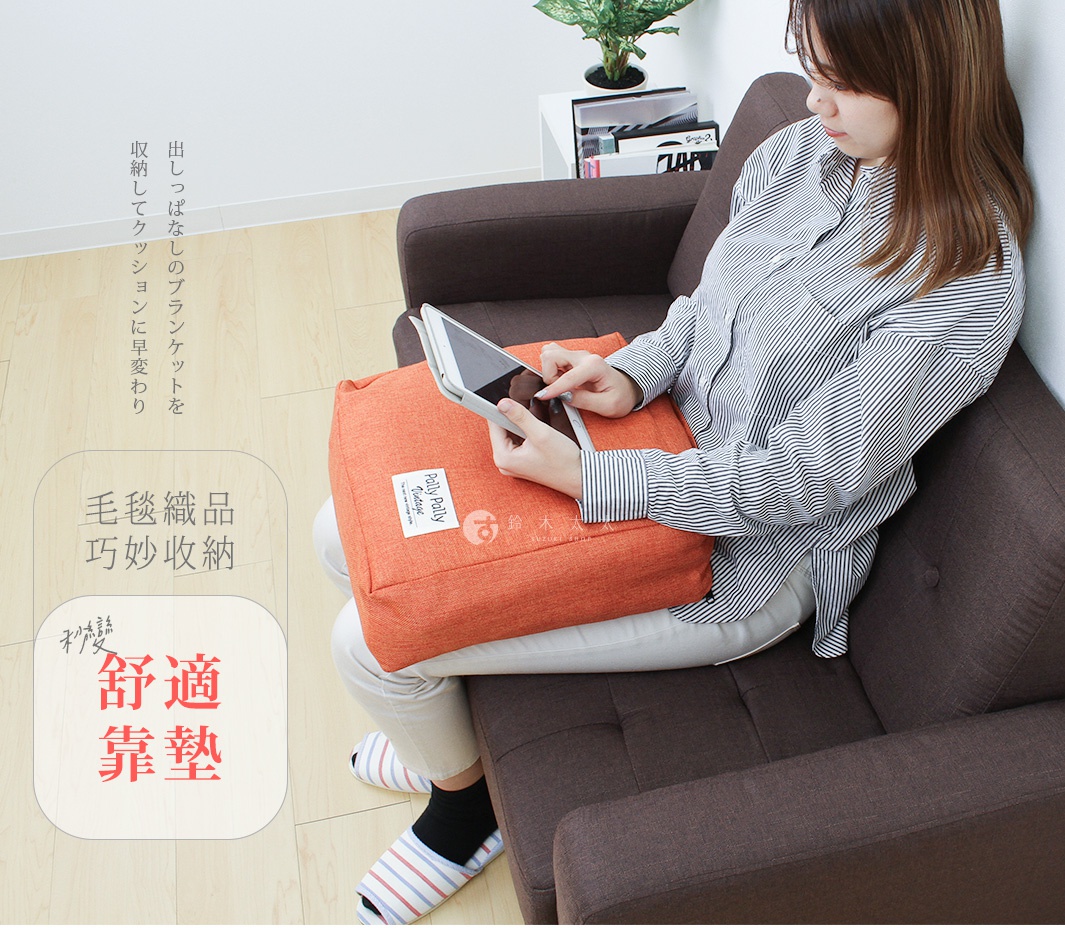 一位年輕女性坐在深棕色沙發上，雙手拿著平板電腦，腿上放著一個明亮的橘色方形布質靠墊。該靠墊上縫有標籤，作為多用途的薄被收納袋使用，整體氛圍呈現居家休閒感。圖片左側包含介紹該商品可將毛毯收納為靠墊的日文說明及標題文字。