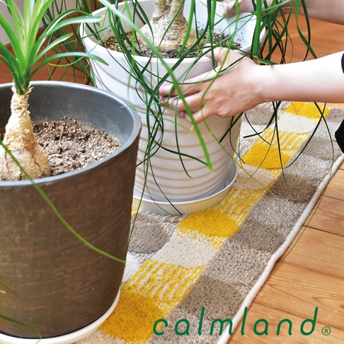 北歐風藝術居家地墊，採用柔軟材質，以米色、淺灰與亮黃色塊交織成格紋圖案，適合居家空間擺設。