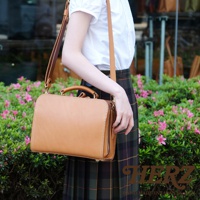 職人手作淺棕色皮革方形兩用單肩包，附有提把和可調式長背帶，採用拉鍊開合。