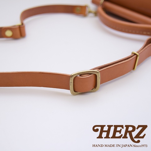 HERZ 職人手作皮革屋瓦風兩用單肩包，側寫其品牌標誌及日製手作說明