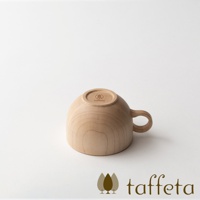 一個由淺色楓木製成的茶杯，杯身圓潤，帶有一個彎曲的把手。杯底朝上，印有品牌標誌和名稱。