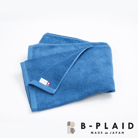 藍色 EVE 今治強韌薄手鱗紋浴巾，材質為棉，觸感柔軟，帶有細緻的鱗紋織紋，角落處有品牌標籤。