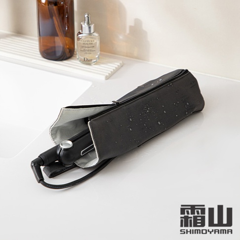 黑色捲髮棒隔熱收納袋，外層為防水材質，內襯為銀灰色，拉鍊設計，袋身有水珠。