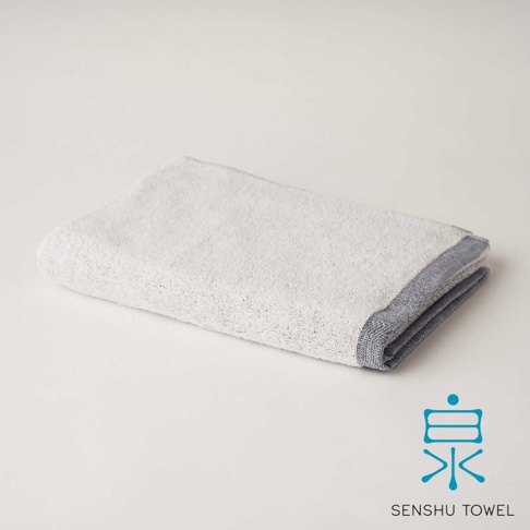 YUKINONE 雪之音柔織有機棉迷你浴巾，顏色為淺灰色，織邊為深藍色條紋，材質為有機棉。