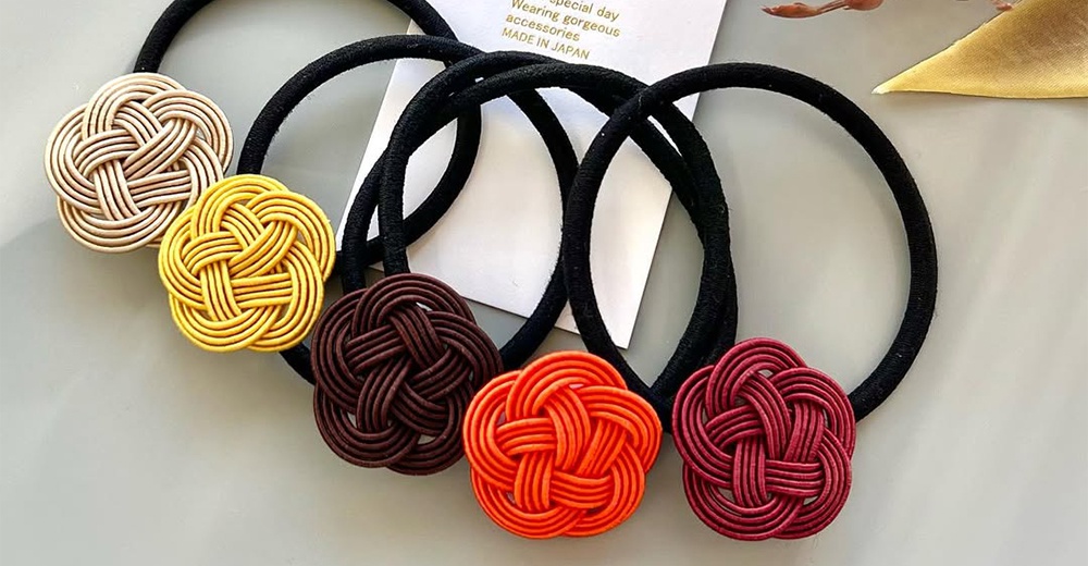五個和風水引花結素色髮圈，分別為米白色、金黃色、深咖啡色、橘紅色和酒紅色，皆搭配黑色髮圈。