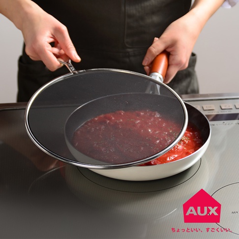 leye 24cm 低反光黑色透視防噴濾網，由細密網格製成，帶有銀色金屬邊框和木質手柄，覆蓋著一個裝有紅色醬料的白色平底鍋，鍋在廚房爐灶上。