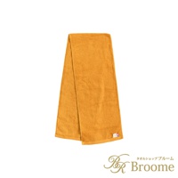 一條橘黃色的今治純棉掛脖毛巾，材質柔軟，有兩個標籤，其中一個標有「Broome」字樣。