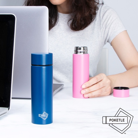 桌面上擺放著一個藍色和一個粉紅色的口袋保溫杯，兩者皆為圓柱形，帶有金屬瓶蓋。左邊的藍色保溫杯上印有白色標誌。右邊的粉紅色保溫杯由一位女士的手握持，瓶蓋則放在一旁。