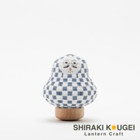 達摩不倒翁造型迷你提燈，燈身為白色紙質，印有藍色棋格紋圖案，臉部繪有黑色鬍鬚、眼睛和嘴巴。提燈底部為圓形木質底座。