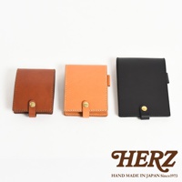 三款職人手作皮革便利貼收納套，分別為棕色、橘色和黑色，皆為牛皮材質，採用車縫線裝飾，並以金色釦環固定。