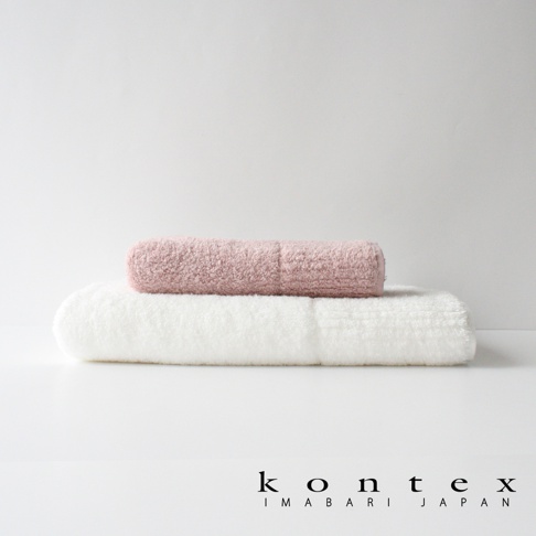 兩條今治毛巾堆疊，下方為白色，上方為粉紅色，材質蓬鬆柔軟。