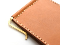 職人手作皮革鈔票夾，淺棕色皮革，搭配金色金屬夾，縫線精緻，質感細膩。