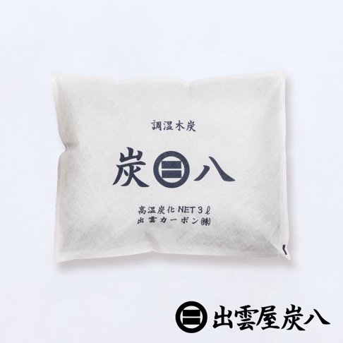 白色無紡布包裝，內含黑色調濕木炭。包裝正面印有深藍色日文「調濕木炭」和「炭八」字樣，以及「高温炭化 NET 3ℓ 出雲カーポン(株)」。底部有品牌標誌和日文「出雲屋炭八」。