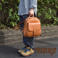 棕色皮革迷你後背包，有立體前袋和皮帶扣，雙肩帶，適合休閒搭配。