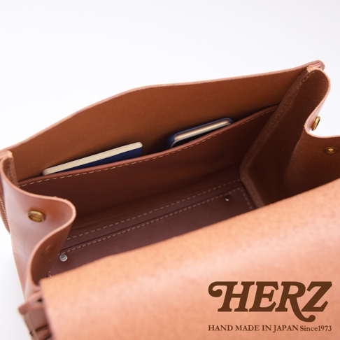 日本HERZ職人手作皮革屋瓦風兩用單肩包的內部，可見皮革夾層可放置卡片或筆記本，並印有HERZ品牌標誌。
