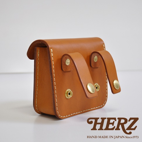 職人手作皮革高爾夫腰包 E-81，採用質感棕色皮革製作，設有兩條皮革繫帶和金色金屬按扣，展現簡約實用的設計風格。