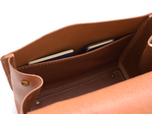 職人手作皮革屋瓦風兩用單肩包 (CW-3)，內部特寫，展示溫潤的淺棕色皮革材質，內袋放置一本藍色封面的小筆記本，細緻縫線清晰可見。