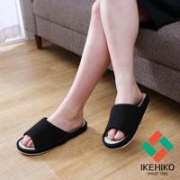 一雙黑色藺草透氣室內拖鞋，鞋面為織布材質，鞋墊為藺草編織，露出腳趾，展示於木質地板上。