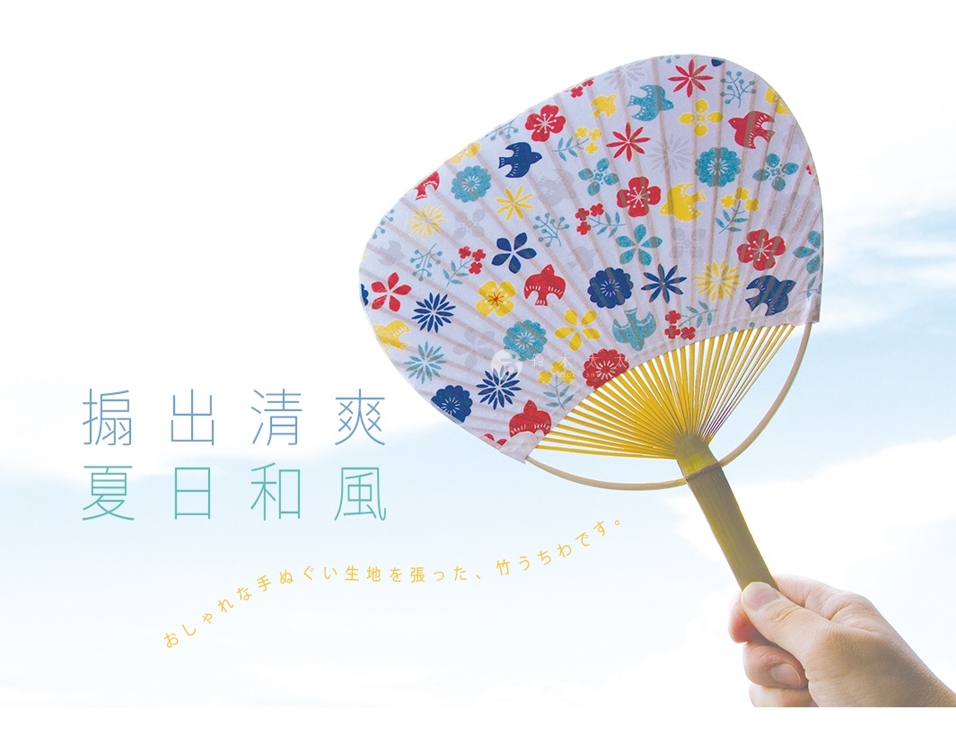 手持一把日式團扇，扇面為白色，印有紅色、藍色、黃色和綠色的小花與鳥圖案，扇骨為黃色竹製。