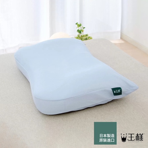 淡藍色王様枕，採用東麗雙倍高吸放濕柔滑材質，枕套觸感柔軟，枕身線條流暢，角落有綠色標籤，標示「日本製造 原裝進口」及「王様」品牌。