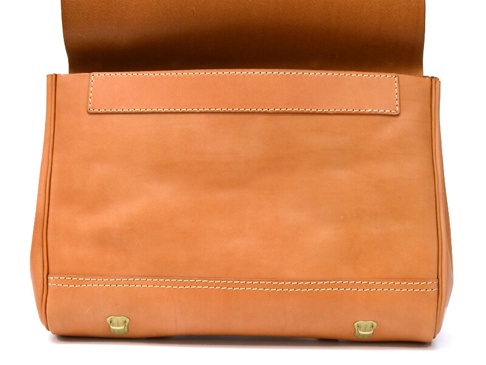 一個淺棕色皮革製成的兩用側背包，包身平整，有精緻縫線裝飾，包蓋向上翻開，露出內裡。包包底部有兩個黃銅色金屬扣環。