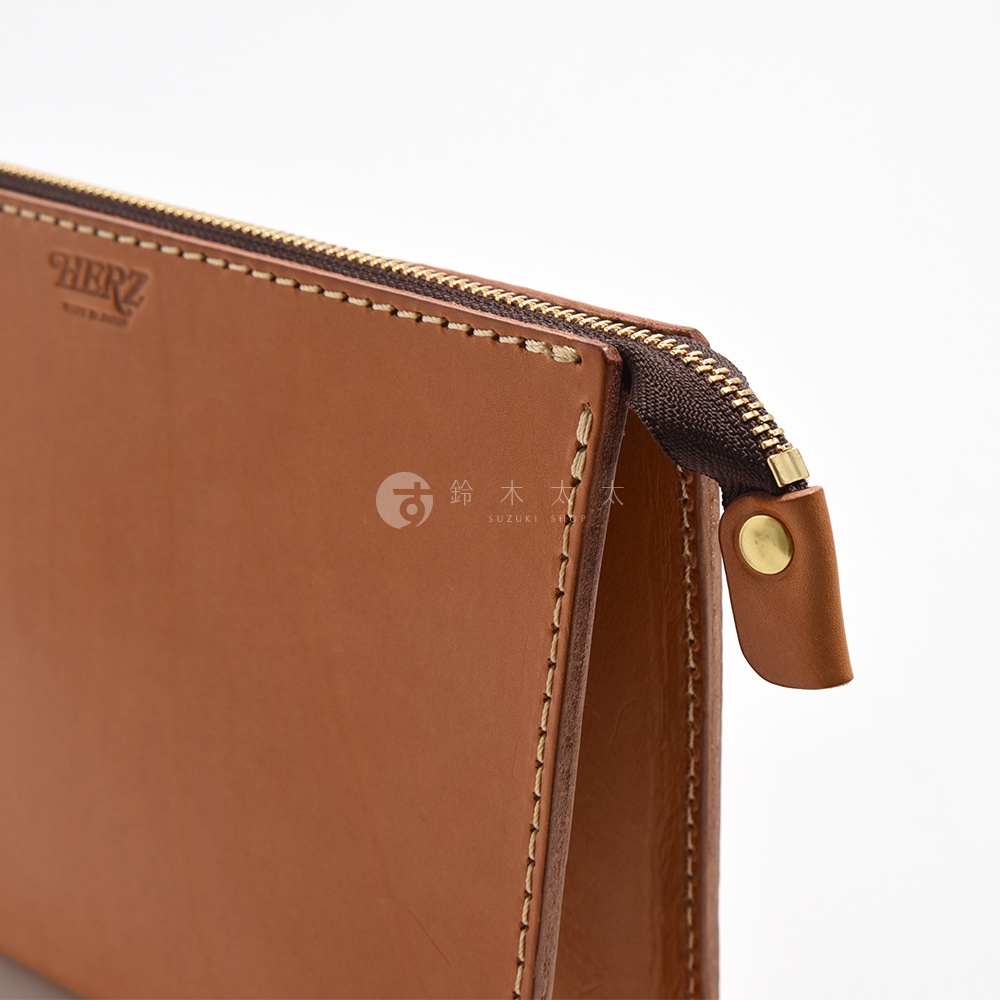 職人手作皮革三角底拉鍊手拿包 S-12，採用棕色皮革材質，搭配黃銅色拉鍊及固定鈕扣，車縫線清晰可見。