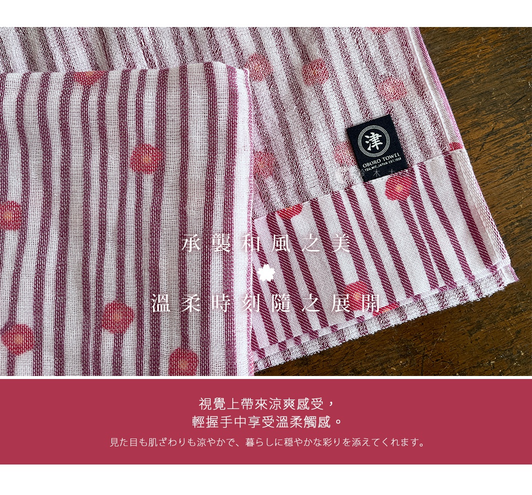 圖片中的日式毛巾，印有細緻條紋與粉色花朵圖案，並飾有「津OBORO」品牌標籤，下方有「承襲和風之美 溫柔時刻隨之展開」等文字，以及「視覺上帶來涼爽感受，輕握手中享受溫柔觸感，見目も肌ざわりも涼やかで、暮らしに穏やかな彩りを添えてくれます。」的介紹。