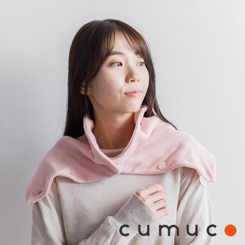 一位女子身穿淡粉色圍脖，頸套上有兩個鈕扣，圍脖內是米色的毛衣，圖片下方有 cumuco 的 logo