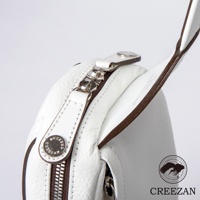 JETTER 隨身側背包 CJTE-021，特寫白色荔枝紋皮革的拉鍊與品牌金屬鈕扣，側邊為深棕色滾邊。