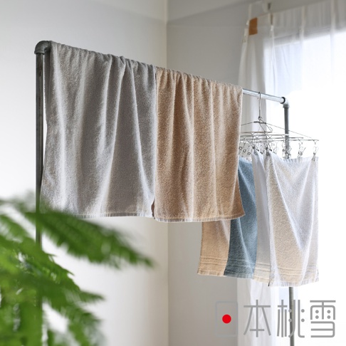 四條 Lite! 輕生活快適速乾薄手迷你浴巾，分別為淺灰色、燕麥色、淺藍色及白色，皆為毛圈材質，懸掛於金屬曬衣架上。