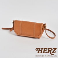 復古風格的棕色皮革郵差包，包身有明顯的白色縫線裝飾，搭配一條細長的皮革背帶，整體呈現簡潔的設計。