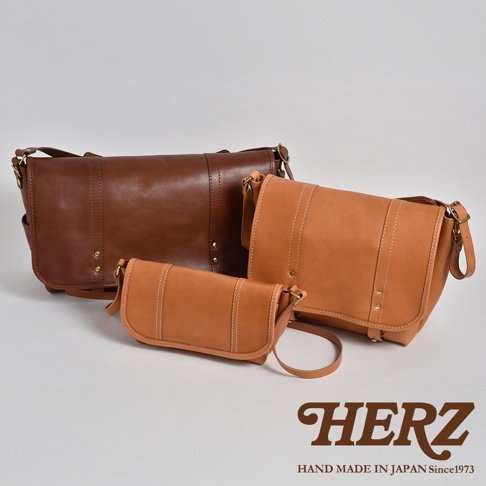 三個不同尺寸的職人手作皮革復古郵差包，使用棕色和淺棕色皮革製成，帶有對比縫線和金屬扣飾。