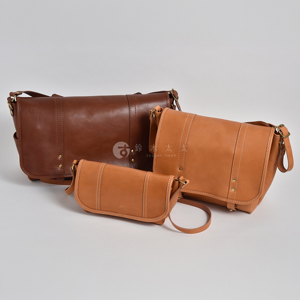 三個職人手作皮革復古郵差包，分別為深棕色、淺棕色和自然色。包款設計簡約，皮革質感佳，有明顯的縫線和金屬鉚釘裝飾。