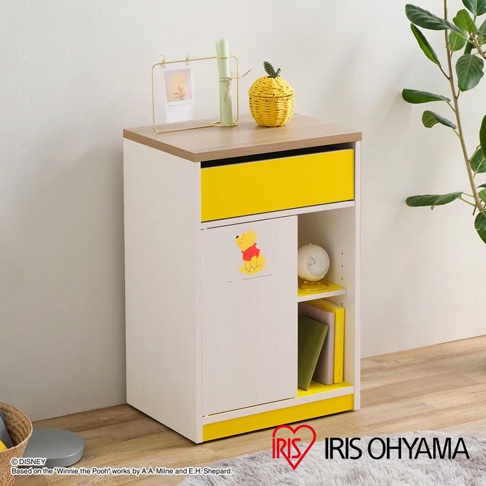 迪士尼系列木質五格桌邊收納櫃，白色櫃體搭配木紋檯面與黃色抽屜，左側門板有小熊維尼圖案，右側開放式層架擺放書籍與時鐘，底部及檯面有黃色裝飾。