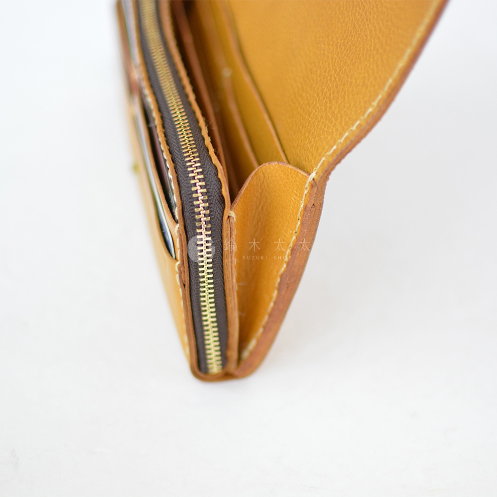 職人手作皮革長夾，採用淺棕色皮革，設有金色拉鍊，內部空間寬敞。