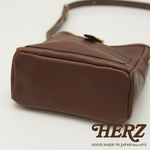 職人手作皮革輕便單肩側背包 CK-91，展現深棕色皮革的紋理，袋身線條簡潔，配有金屬扣環和可調式肩帶，質感細緻。