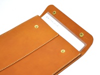 職人手作皮革信封式雙釦手拿袋，採用天然皮革材質，呈現溫潤的棕褐色，車縫線清晰，設有兩個金屬釦及一個透明夾層，可放置文件或卡片。