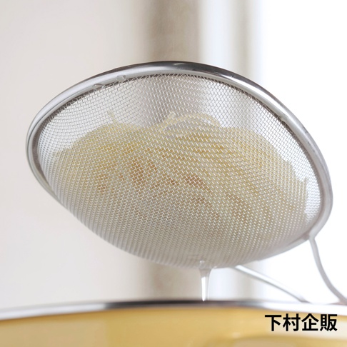 橢圓形不鏽鋼濾網，網孔細密，邊緣有金屬包邊，用於過濾食材。