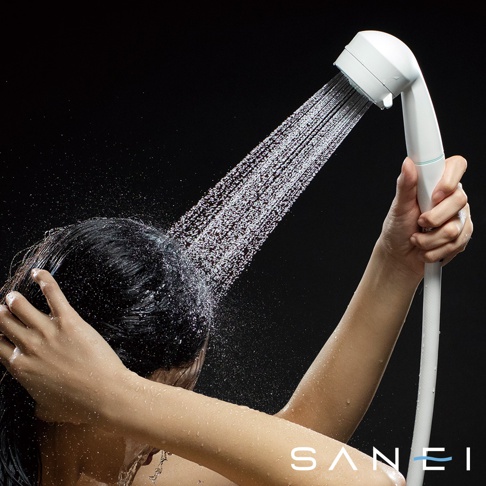 手持白色兩段式水流專髮按摩蓮蓬頭，水柱噴灑在一位正在洗頭的人的頭髮上。