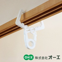 白色塑膠門樑晾掛組，掛臂可調節，附有圓形掛環，夾在木製門框上。