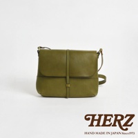 日本HERZ職人手作的綠色皮革細扣帶馬鞍包，以簡約的設計和精緻的工藝呈現。