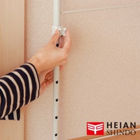 白色金屬伸縮桿，頂端有白色塑膠調節旋鈕，旋鈕旁有黑色調節孔，背景為淺粉色壁紙。