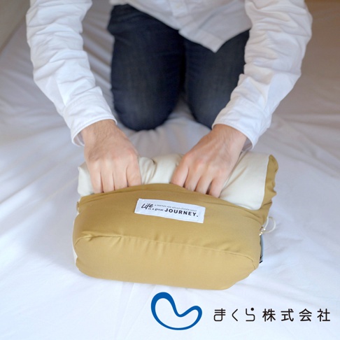 卡其色和米白色的 JOURNEY 旅行便攜枕，枕套材質為柔軟的布料，上面印有「Life is a great JOURNEY.」的白色標籤。